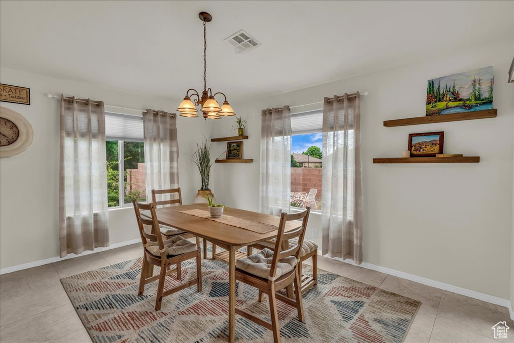 Dining space with plenty of natural light, a chandelier, and light tile patterned floors