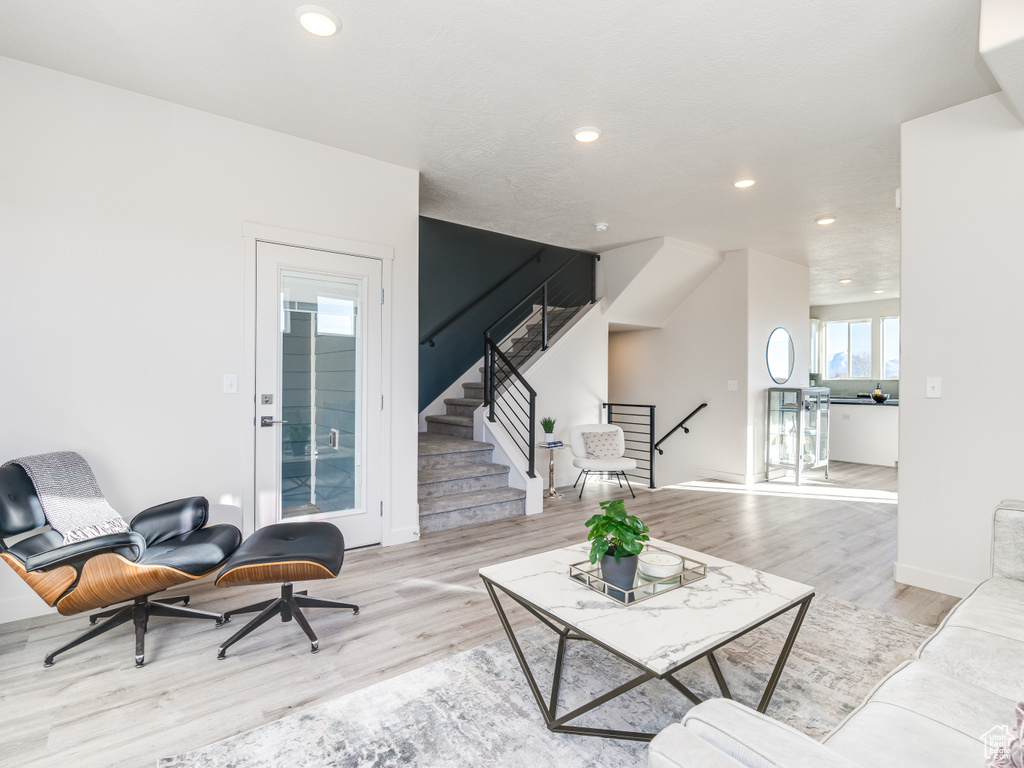 Living room featuring wood finished floors, recessed lighting, stairway, and baseboards