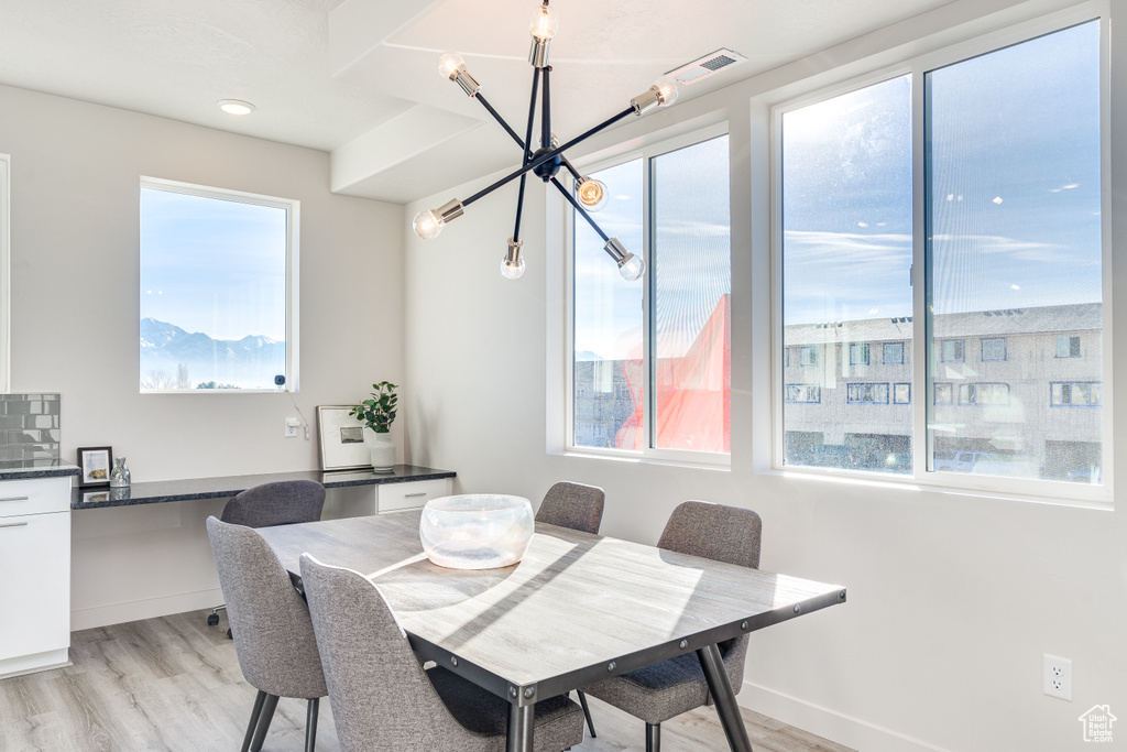 Dining area featuring a chandelier, light wood-style flooring, and baseboards