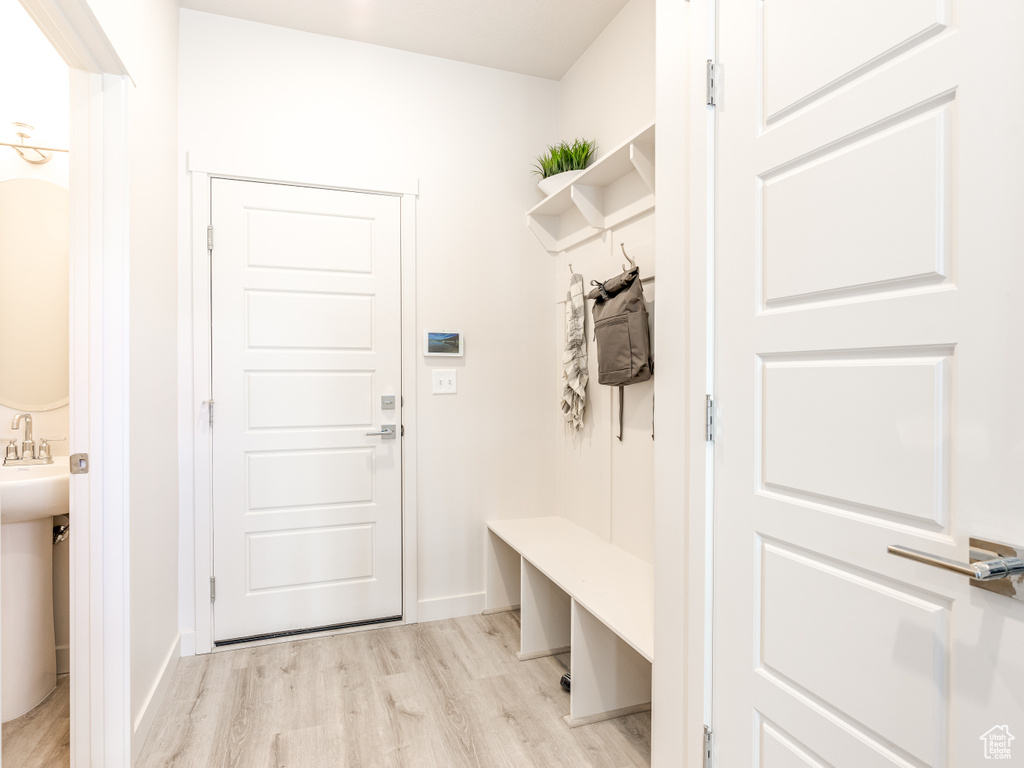 Mudroom featuring light wood-style floors and baseboards