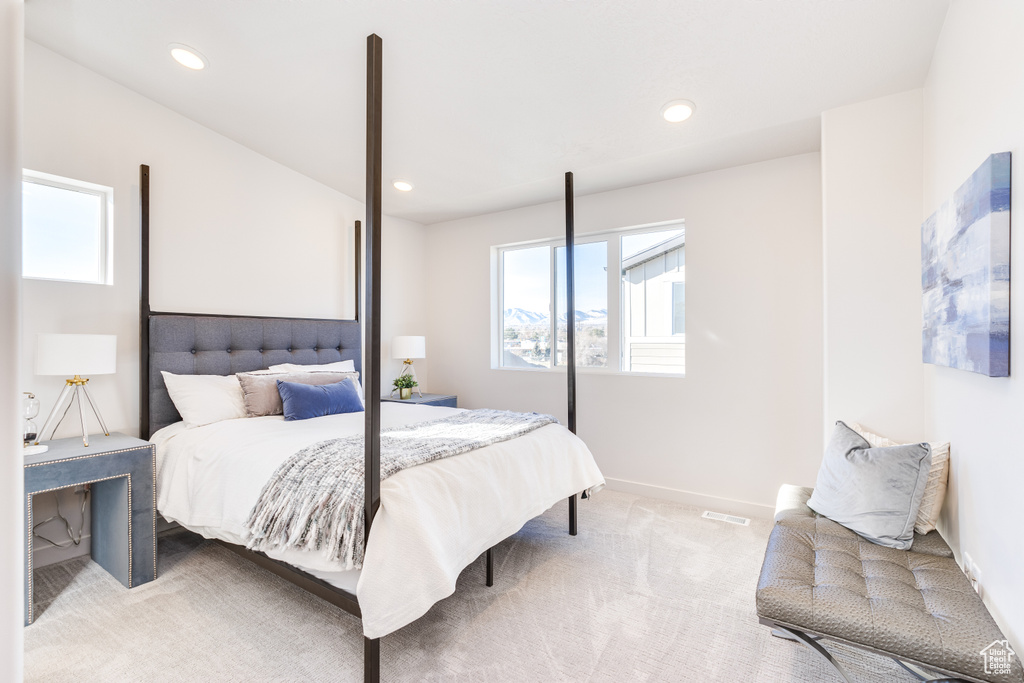 Bedroom featuring multiple windows, light carpet, recessed lighting, and baseboards