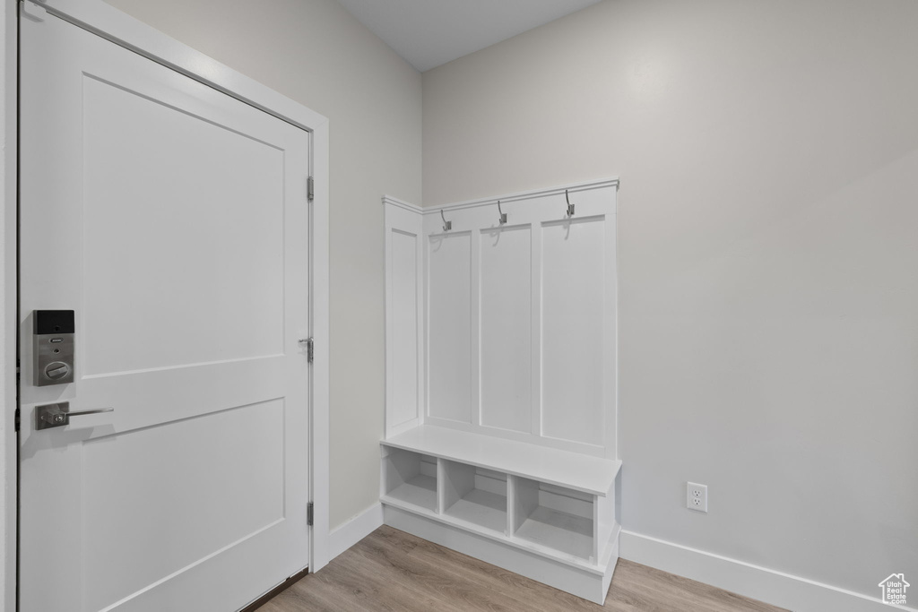 Mudroom with light wood finished floors and baseboards