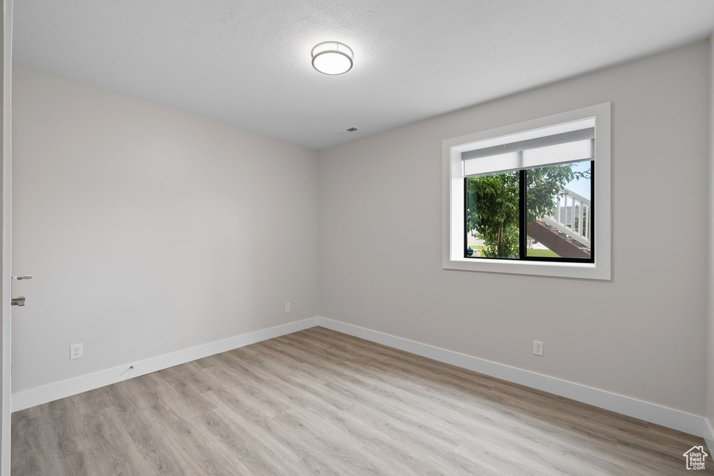 Unfurnished room featuring wood finished floors and baseboards