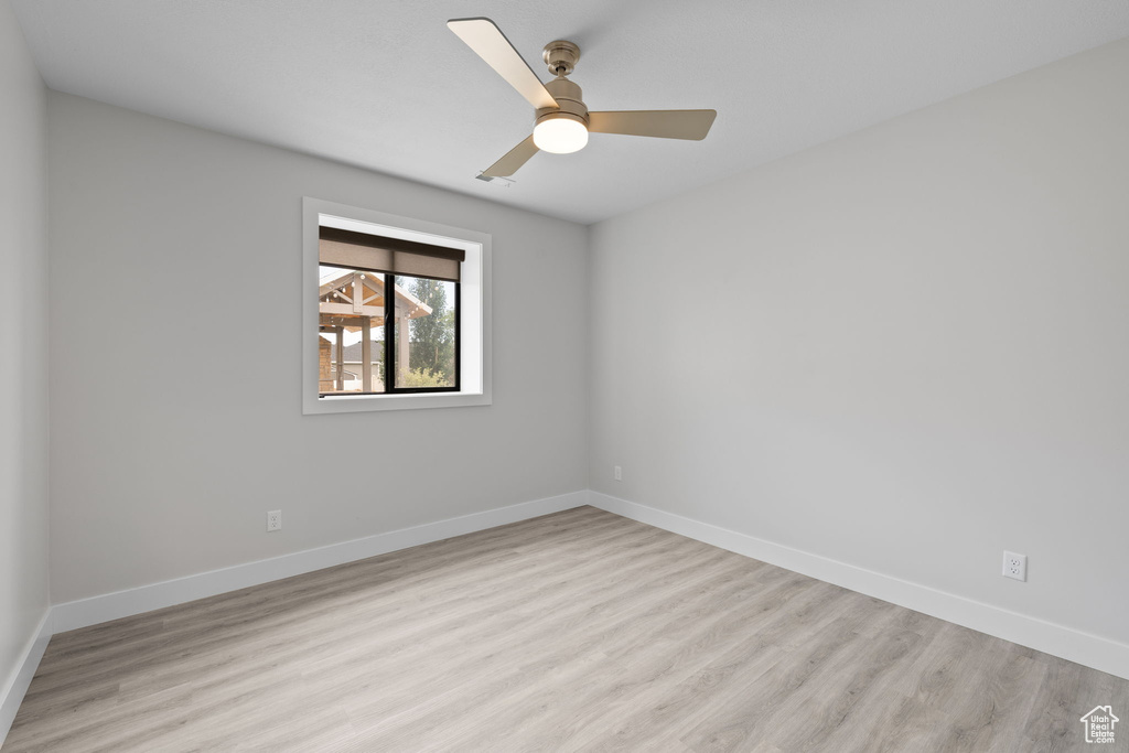 Unfurnished room with wood finished floors, baseboards, and ceiling fan