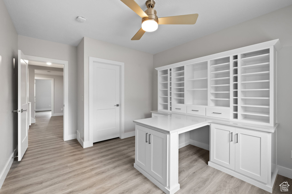 Unfurnished office featuring ceiling fan, baseboards, and light wood-style flooring