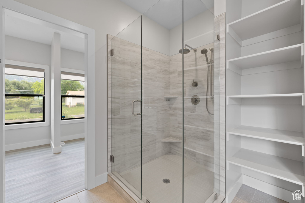 Full bathroom with a shower stall and baseboards