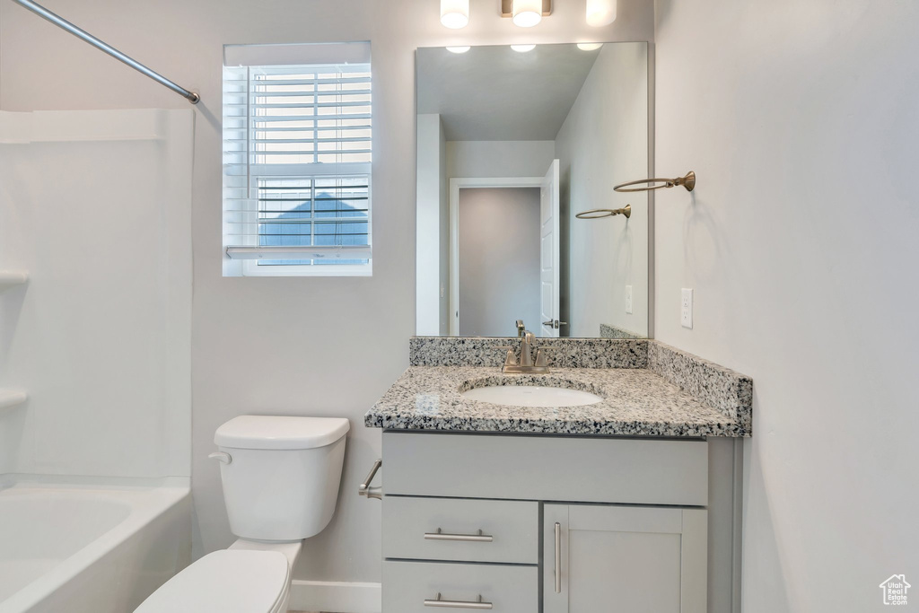 Bathroom with toilet, vanity, and shower / tub combination