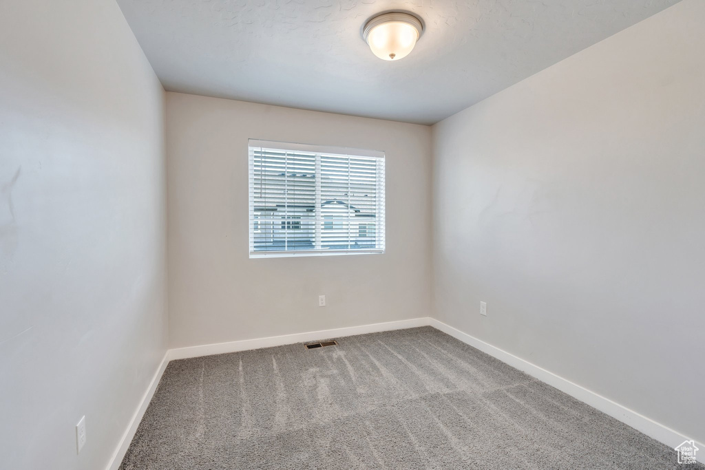 Empty room featuring baseboards and carpet flooring