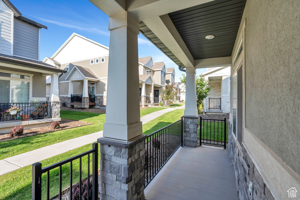 Porch featuring a residential view and a lawn