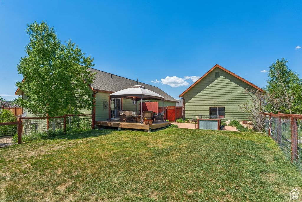 Rear view of property featuring a gazebo and a deck