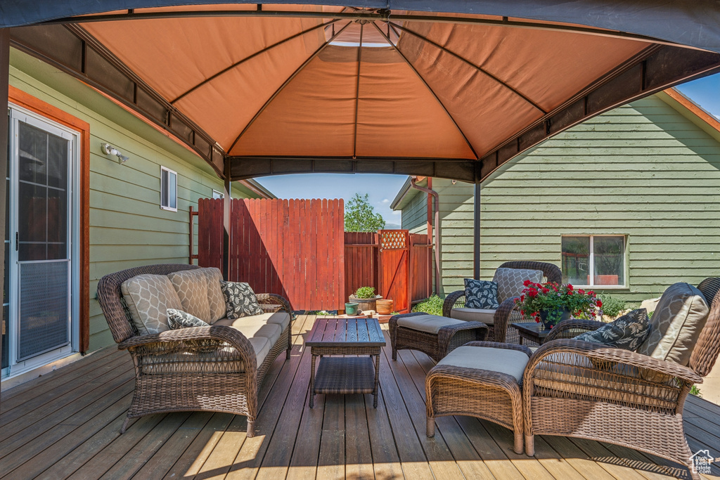 Wooden deck featuring an outdoor hangout area and a gazebo