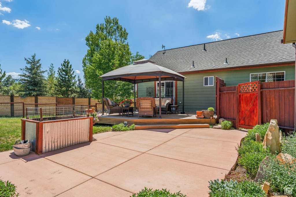 Back of house with a gazebo, a patio area, a shingled roof, and outdoor lounge area