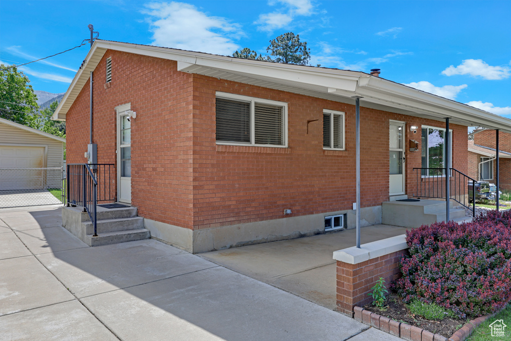 View of front of home featuring brick siding and an outdoor structure