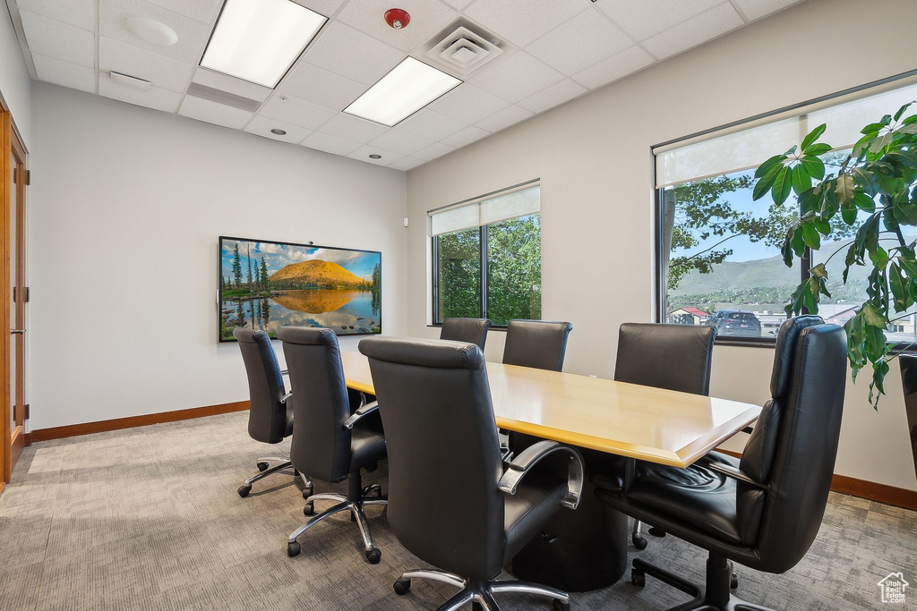 Office with light colored carpet, baseboards, and a drop ceiling