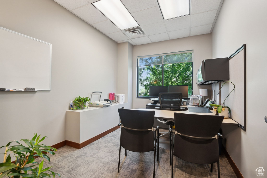 Home office with a drop ceiling and baseboards