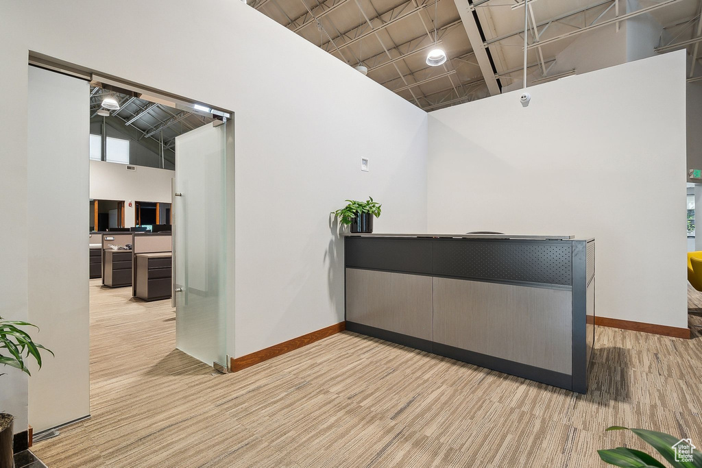 Bar featuring a high ceiling, baseboards, and light colored carpet