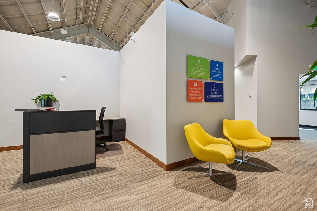 Home office featuring baseboards, high vaulted ceiling, and carpet flooring