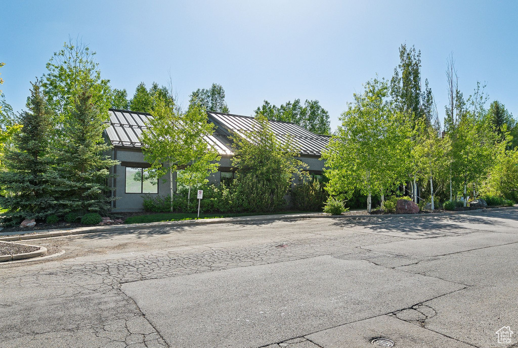 View of property hidden behind natural elements featuring a standing seam roof and metal roof