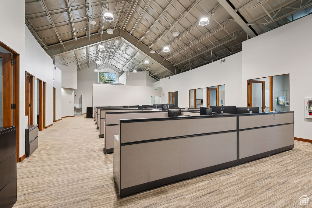Miscellaneous room featuring high vaulted ceiling and baseboards