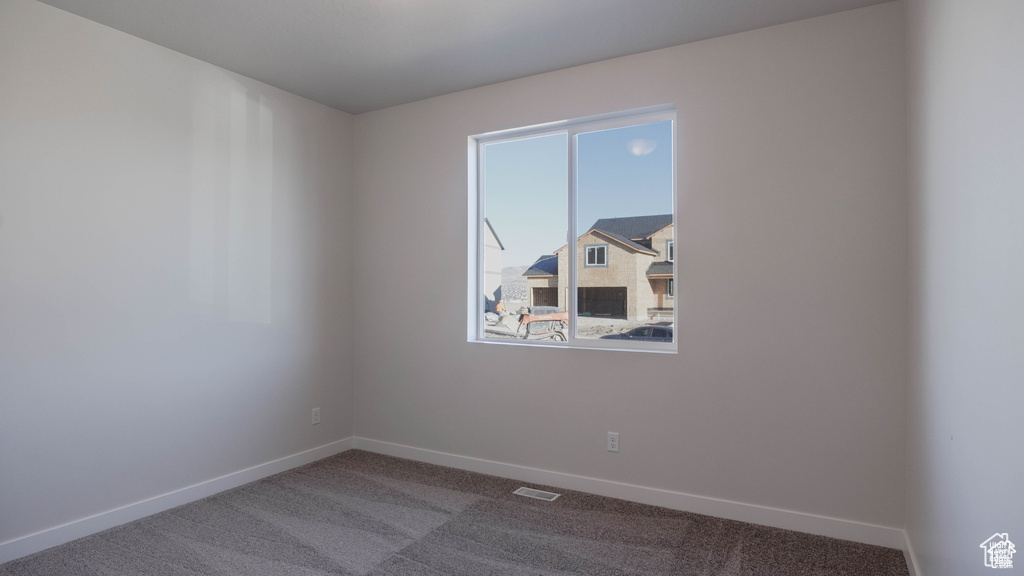 Spare room with baseboards and carpet floors