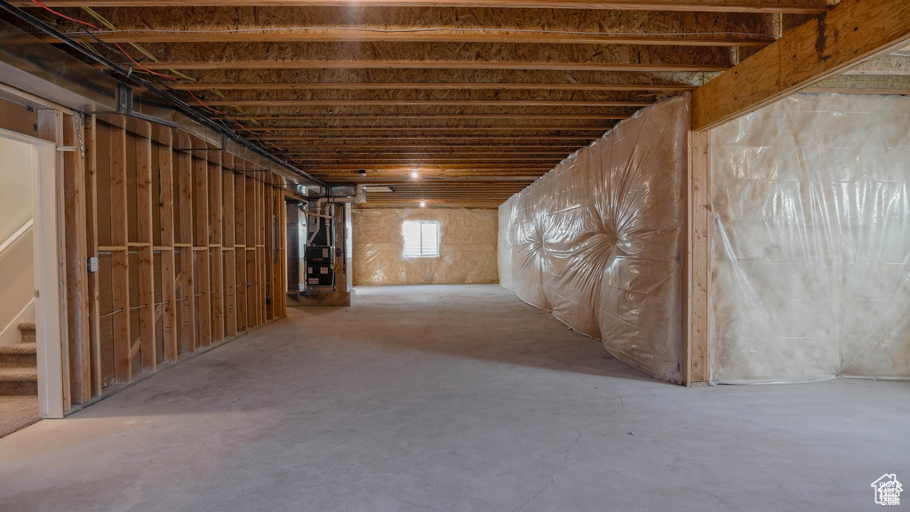 Basement with heating unit and stairway