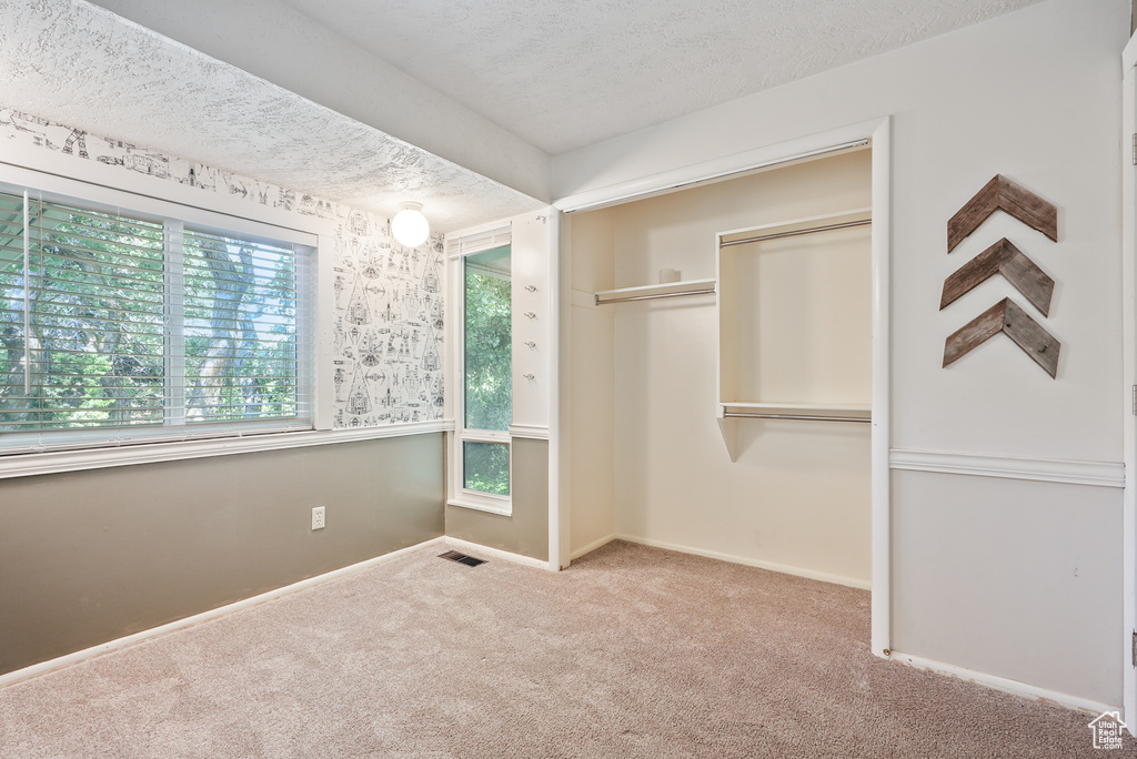 Unfurnished bedroom featuring carpet, a closet, and baseboards