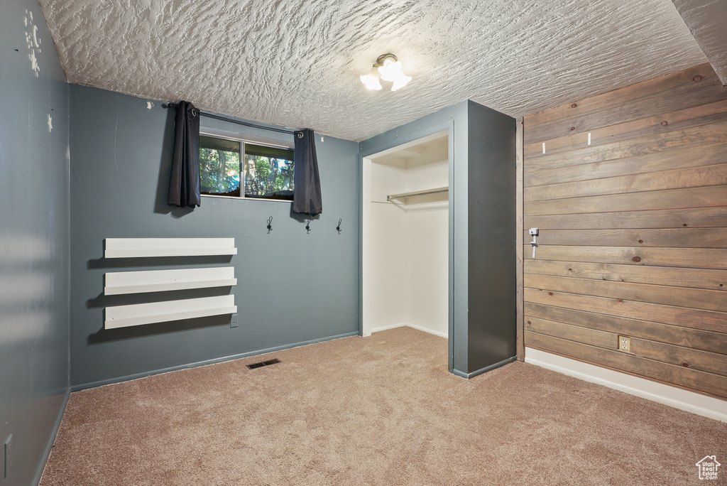 Unfurnished bedroom with carpet, a closet, baseboards, and a textured ceiling