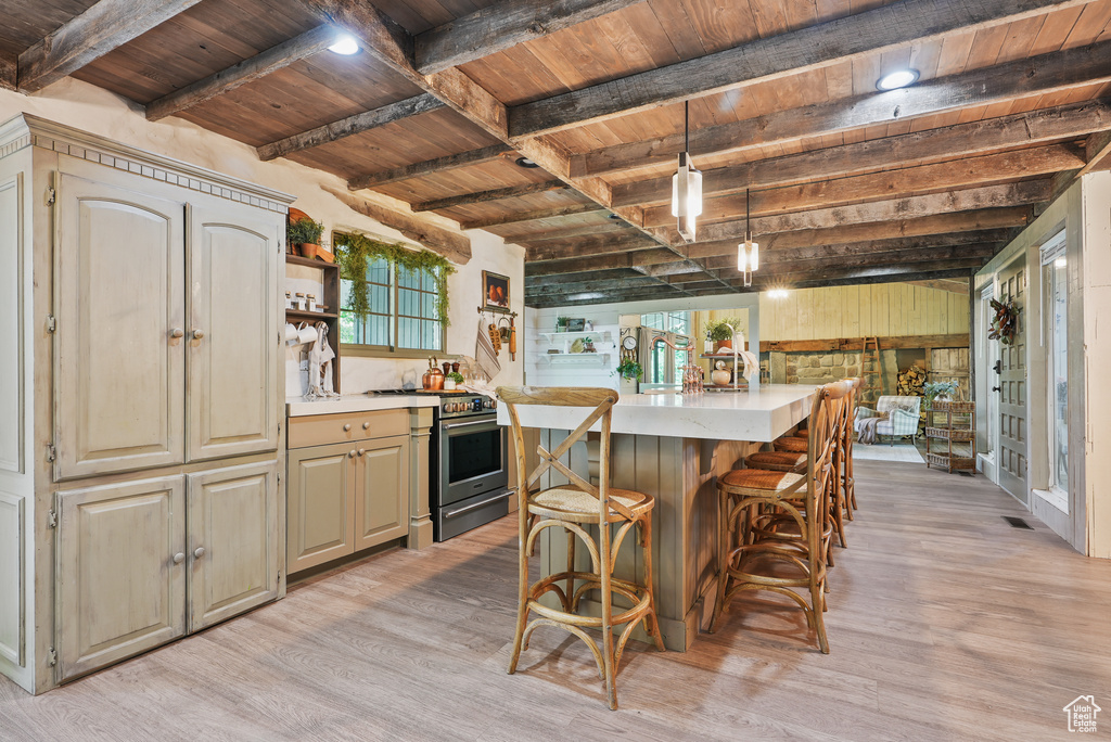 Kitchen featuring stainless steel range, wood ceiling with exposed beams, light wood-style floors, light countertops, and open shelves