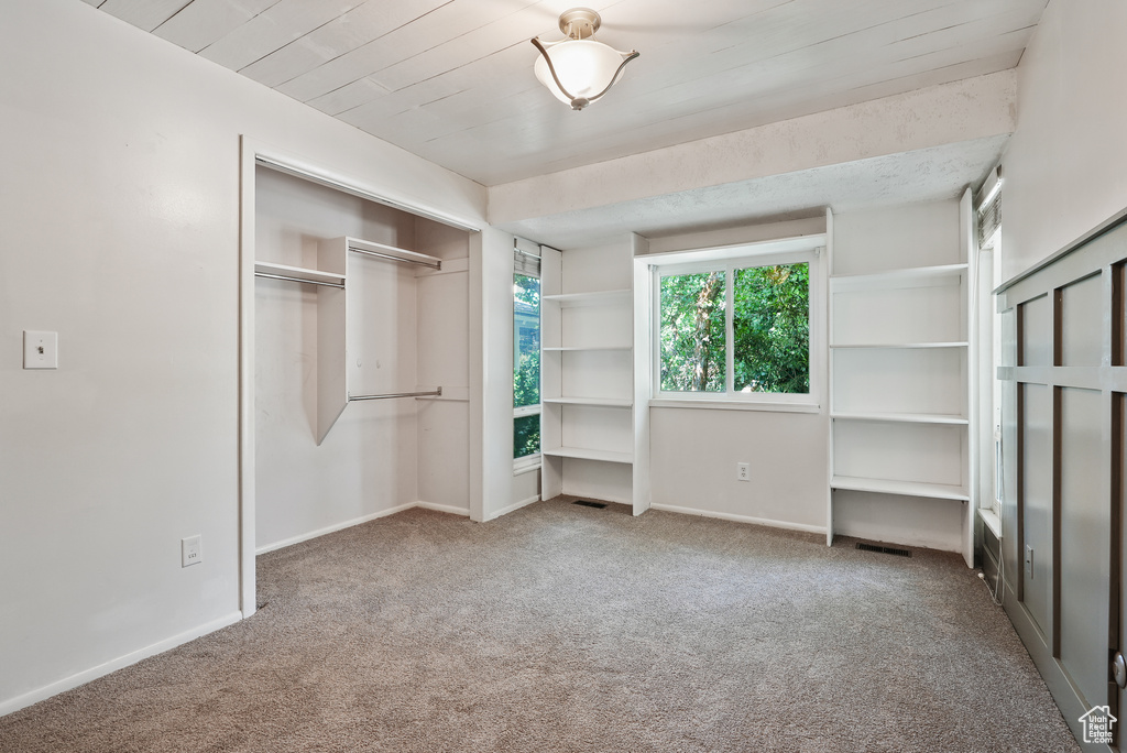 Unfurnished bedroom with carpet floors, baseboards, and a closet