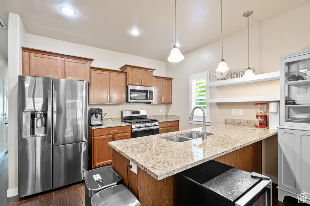 Kitchen with stainless steel appliances, a sink, open shelves, a peninsula, and brown cabinets