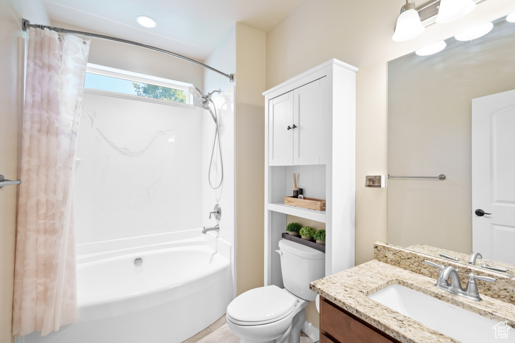 Bathroom featuring shower / bath combination with curtain, vanity, and toilet