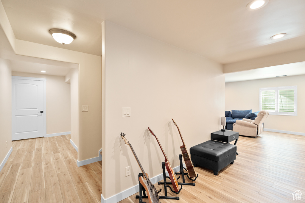 Hallway featuring light wood-style floors, baseboards, and recessed lighting