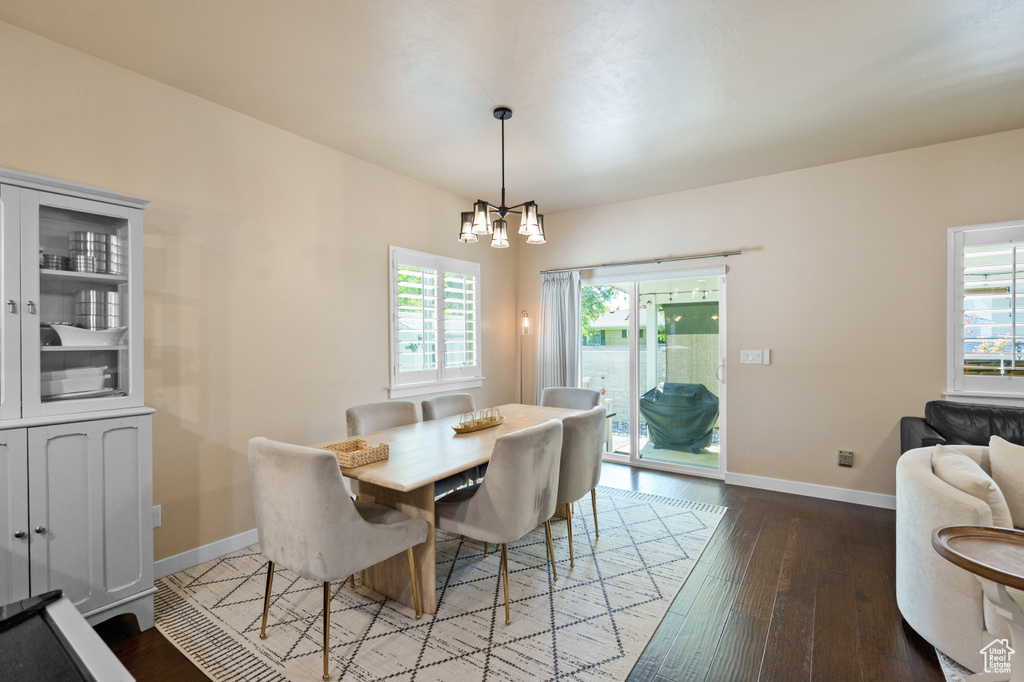 Dining room featuring a chandelier, hardwood / wood-style floors, and baseboards