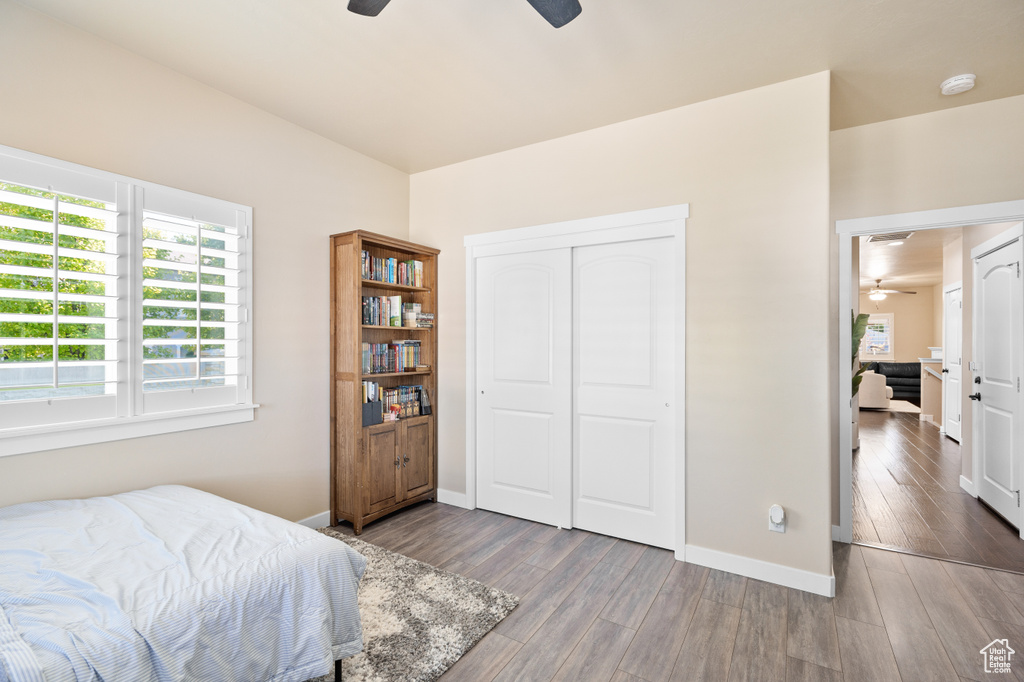 Bedroom with baseboards, wood finished floors, a closet, and a ceiling fan