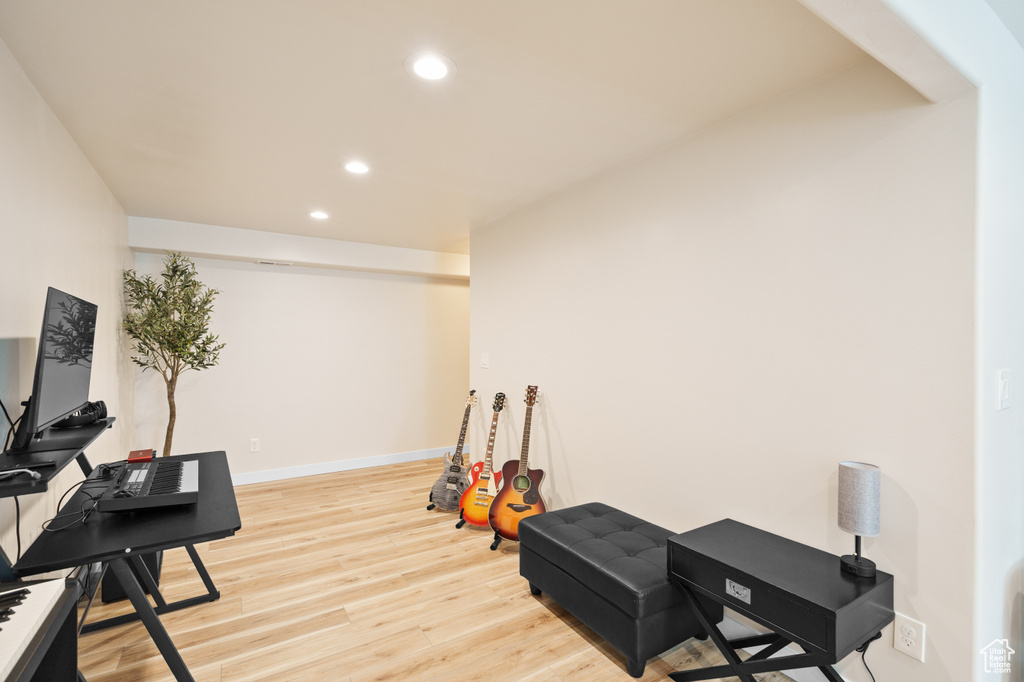 Exercise area with recessed lighting, light wood-style flooring, and baseboards