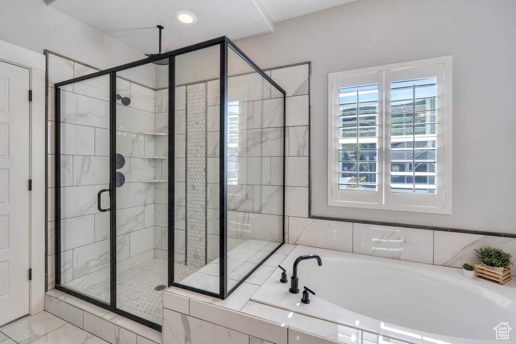 Bathroom with a bath, a stall shower, and marble finish flooring
