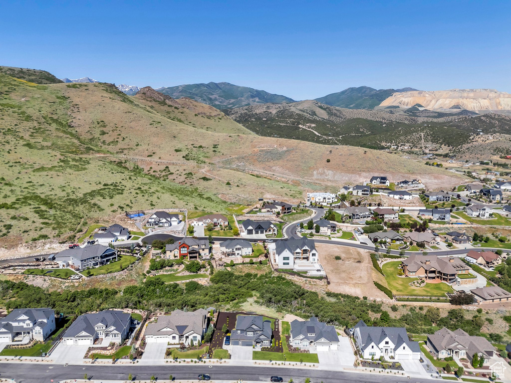 Aerial view of property and surrounding area featuring nearby suburban area and mountains