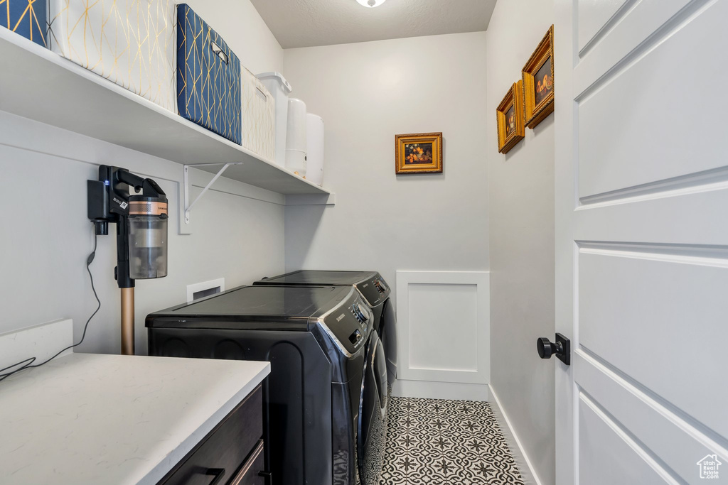 Laundry room featuring washer and clothes dryer and tile patterned flooring
