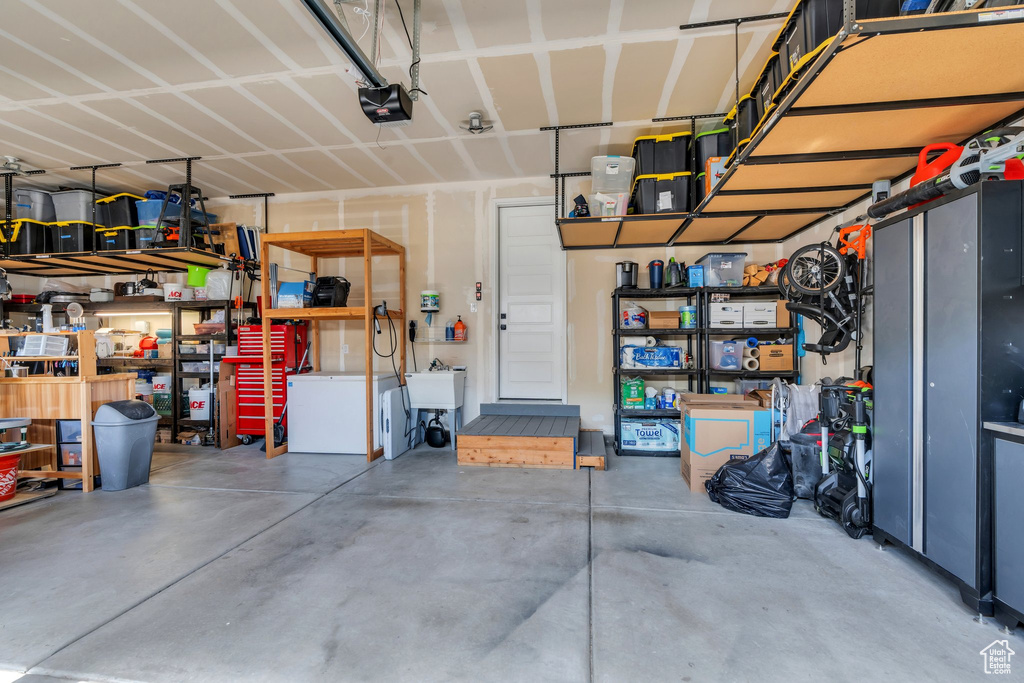 Garage featuring a garage door opener and a sink