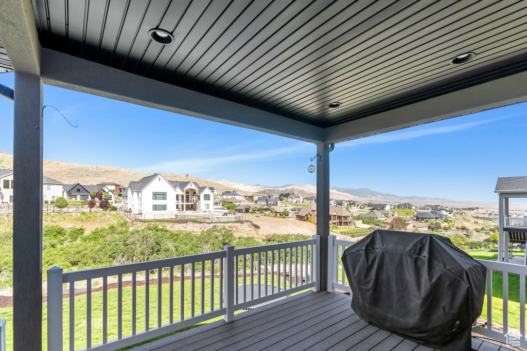 Wooden deck with a residential view, grilling area, a mountain view, and a lawn