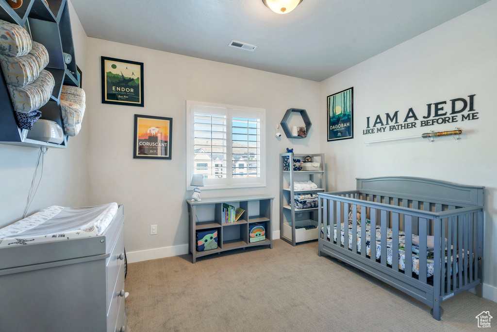 Bedroom with carpet, baseboards, and a crib
