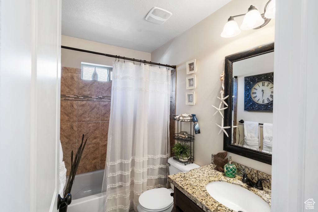 Full bath with vanity, toilet, and shower / bath combination with curtain