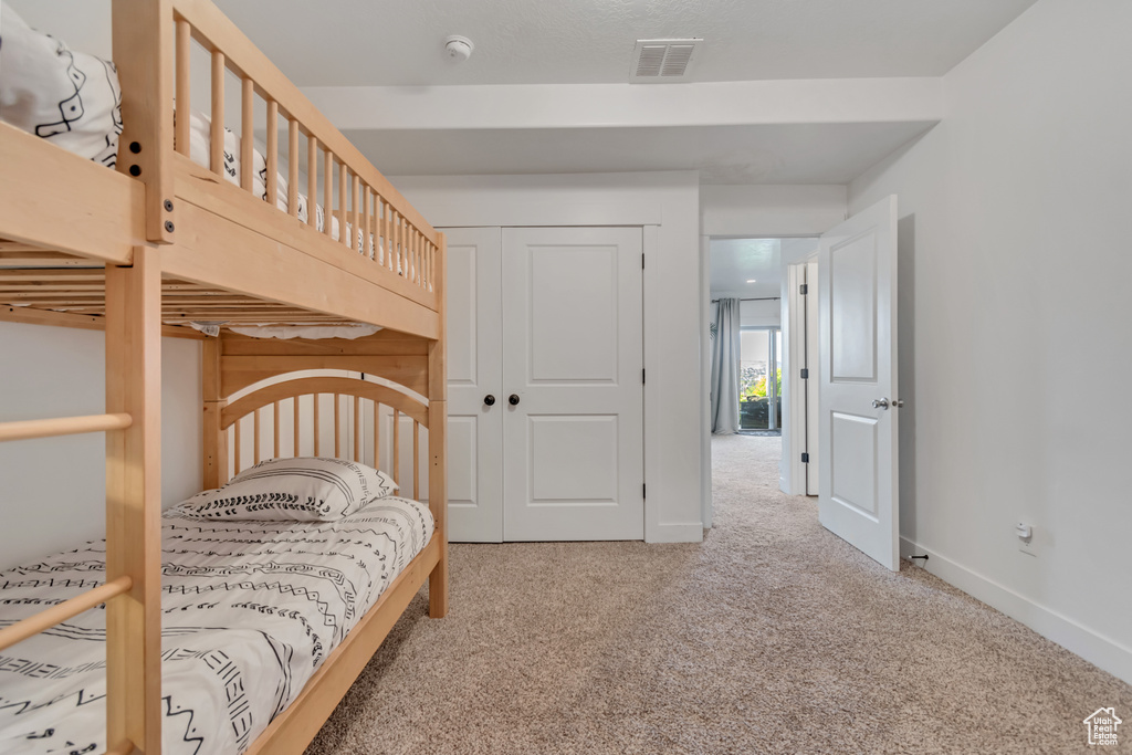 Carpeted bedroom featuring a closet and baseboards