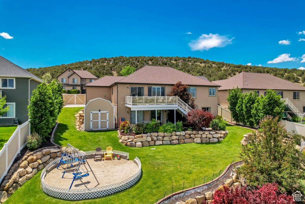 Back of house featuring stairs, a wooden deck, stucco siding, a residential view, and a patio