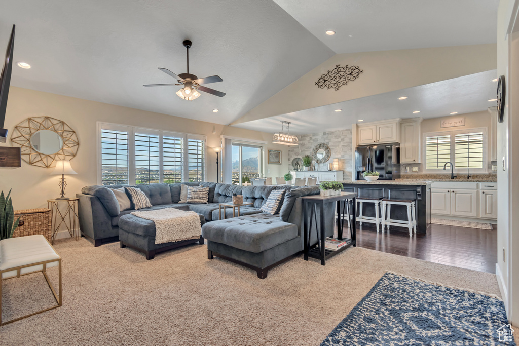 Living area featuring a ceiling fan, vaulted ceiling, dark colored carpet, and recessed lighting