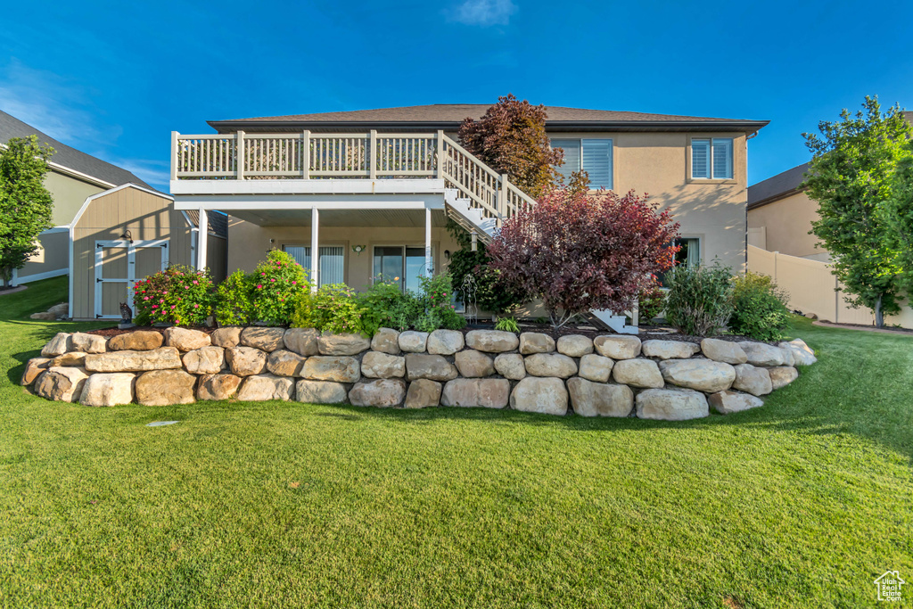 Back of property with stucco siding, stairway, and a wooden deck