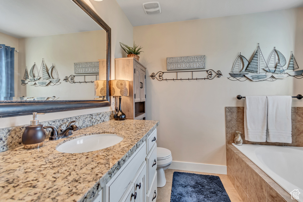 Bathroom with vanity, a bath, baseboards, toilet, and tile patterned flooring