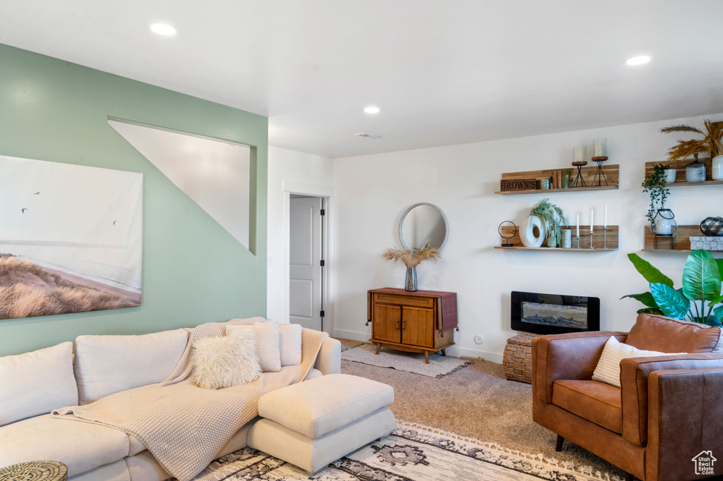 Living room with recessed lighting, carpet flooring, a glass covered fireplace, and baseboards