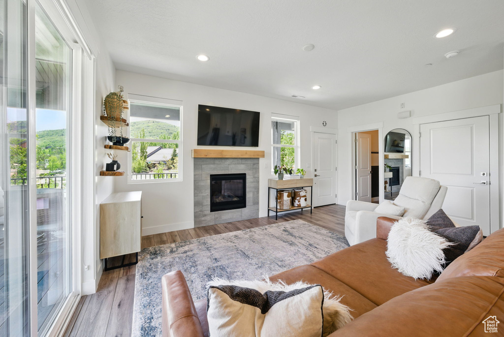 Living area featuring a tile fireplace, wood finished floors, recessed lighting, and baseboards