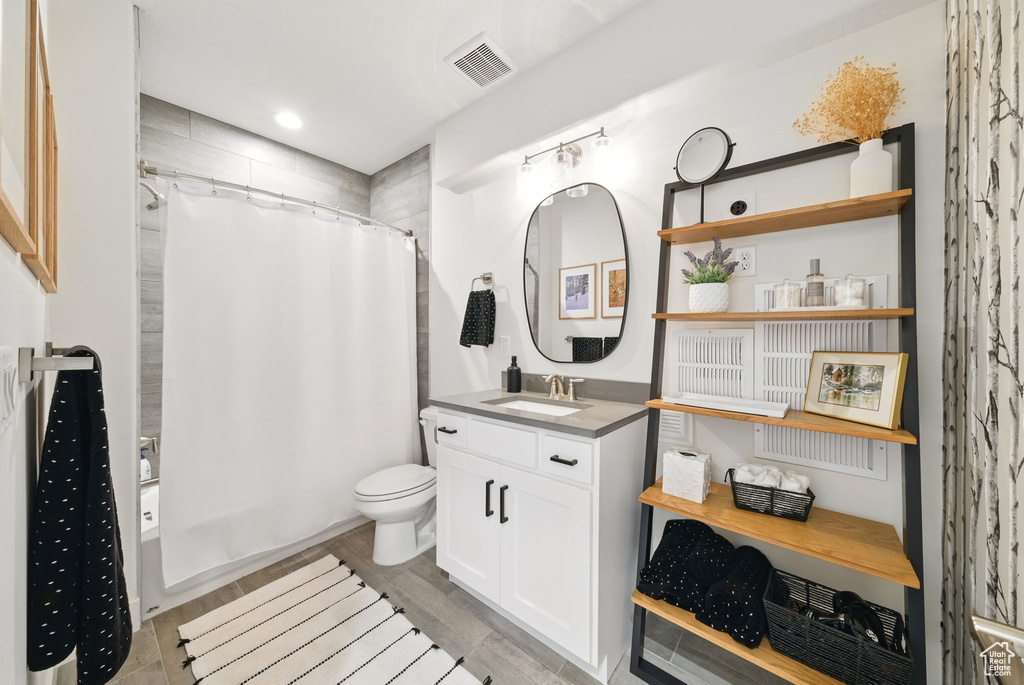 Bathroom with vanity, shower / bath combo with shower curtain, toilet, and recessed lighting